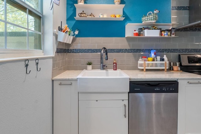220 Casey Rd, Lufkin, TX 75901 - kitchen with stainless steel dishwasher, open shelves, decorative backsplash, white cabinets, and light stone counters