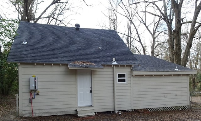 back of property featuring roof with shingles