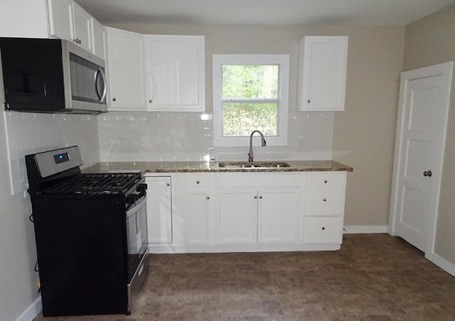 kitchen featuring tasteful backsplash, white cabinets, appliances with stainless steel finishes, light stone countertops, and a sink