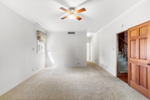 carpeted spare room with ceiling fan and ornamental molding