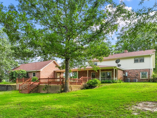 back of property featuring a lawn, central AC unit, and a deck