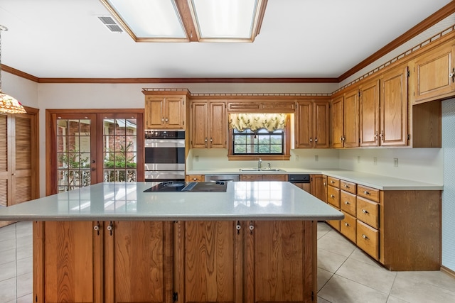 kitchen with sink, a center island, french doors, light tile patterned floors, and appliances with stainless steel finishes