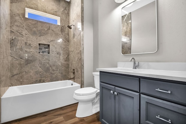 bathroom featuring toilet, washtub / shower combination, wood finished floors, and vanity