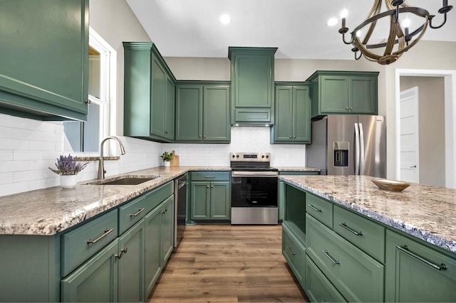 kitchen featuring stainless steel appliances, green cabinets, and a sink