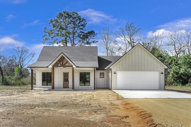 modern farmhouse style home with board and batten siding, driveway, a shingled roof, and a garage