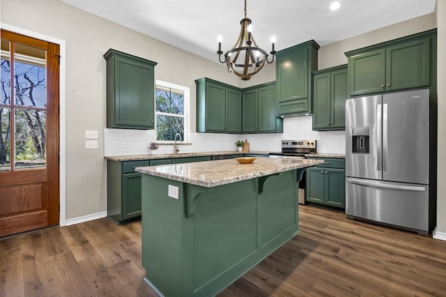 kitchen featuring a kitchen island, light stone counters, a breakfast bar area, hanging light fixtures, and stainless steel appliances