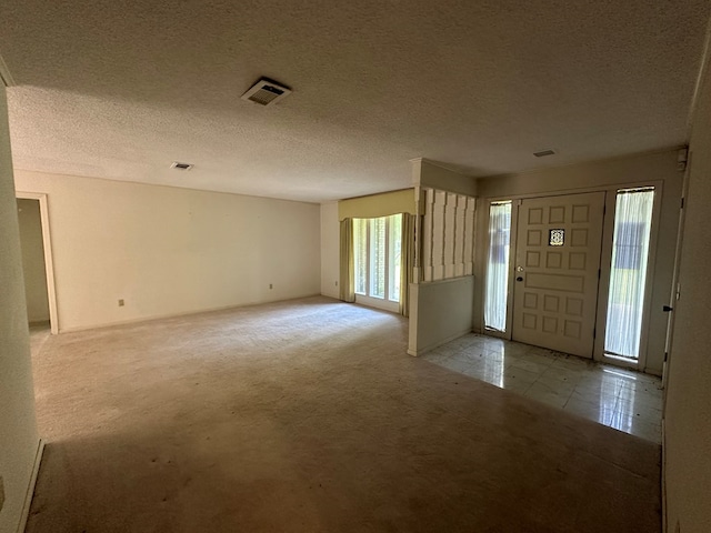 707 Pine St, Center, TX 75935 - carpeted foyer featuring a textured ceiling