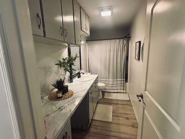 bathroom featuring shower / bath combo, vanity, toilet, and wood finished floors