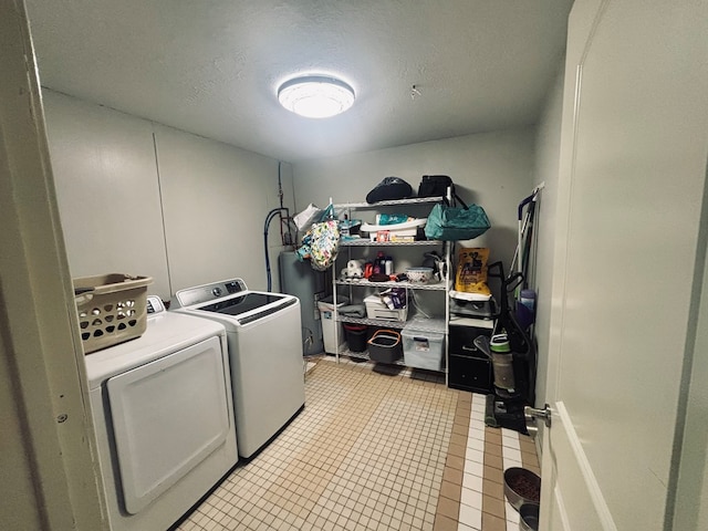 laundry area with laundry area, light tile patterned flooring, a textured ceiling, and independent washer and dryer