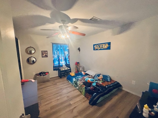 bedroom with light wood-type flooring, ceiling fan, and visible vents