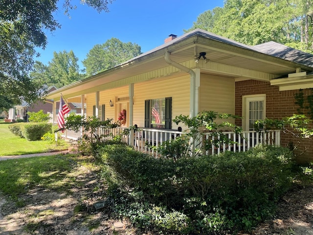 701 Shady Ln, Diboll, TX 75941 - view of front of house featuring covered porch, brick siding, and a chimney