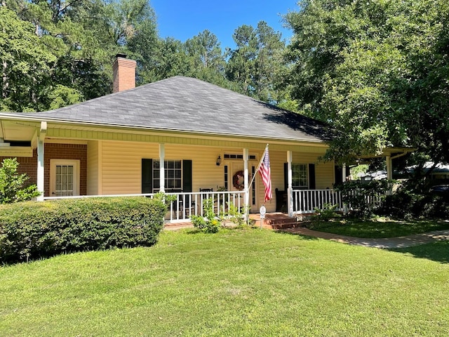 701 Shady Ln, Diboll, TX 75941 - view of front of home with a porch, a chimney, a front lawn, and a shingled roof
