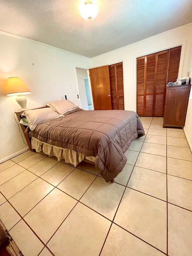 7203 Fm 326, Lufkin, TX 75901 - bedroom with two closets, a textured ceiling, and light tile patterned floors