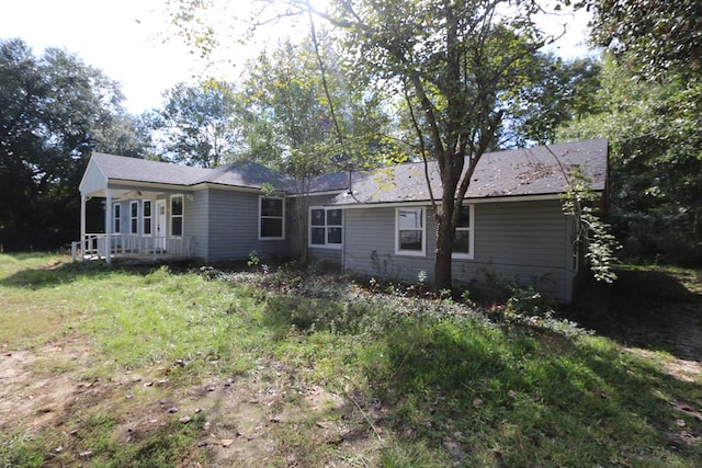 back of house featuring a yard and a porch