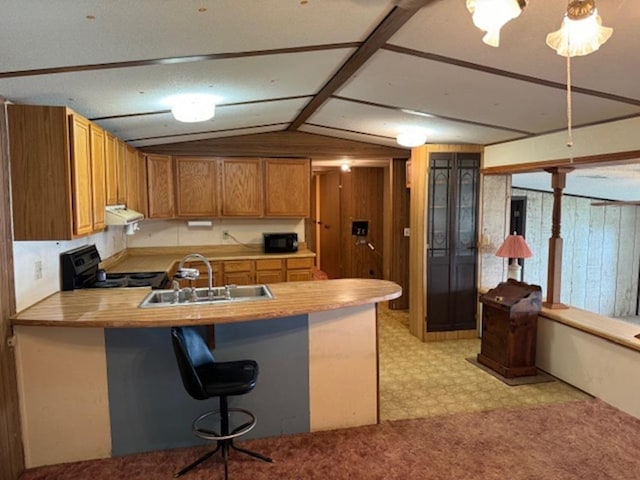 kitchen with sink, exhaust hood, kitchen peninsula, a breakfast bar, and black appliances