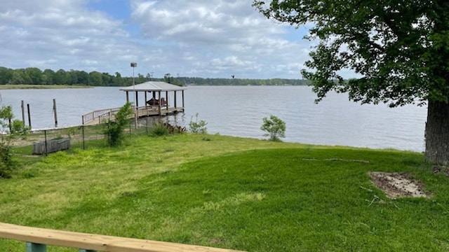 view of dock with a water view and a yard