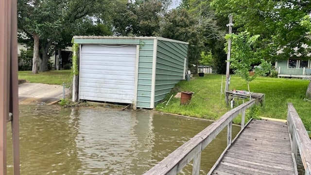 dock area with a lawn and a water view