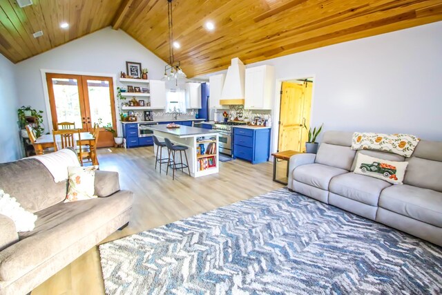 living room with lofted ceiling with beams, light hardwood / wood-style floors, wood ceiling, and french doors