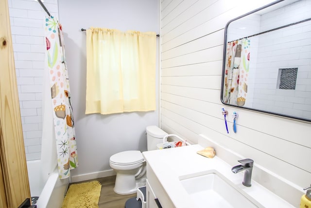 full bathroom featuring vanity, wood walls, hardwood / wood-style flooring, toilet, and shower / bathtub combination with curtain