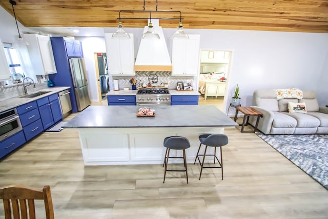 kitchen with white cabinetry, a center island, blue cabinets, and appliances with stainless steel finishes