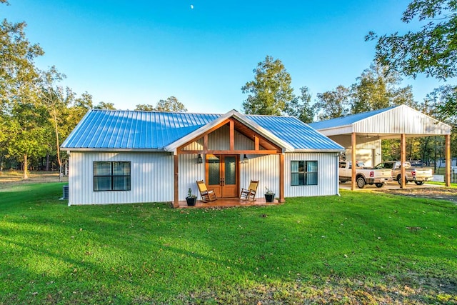 back of property featuring a lawn and a carport