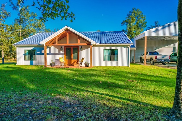 back of house featuring a lawn, a carport, and french doors