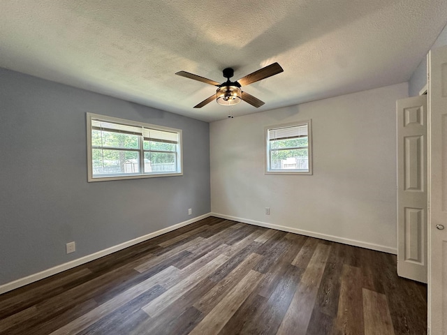 spare room featuring ceiling fan, dark wood-type flooring, and a textured ceiling