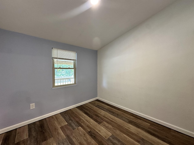 empty room featuring wood-type flooring and vaulted ceiling