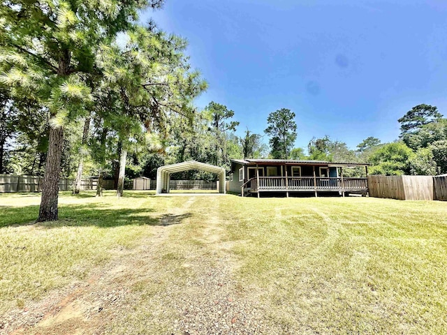 view of front of home with a deck, a front yard, and a carport