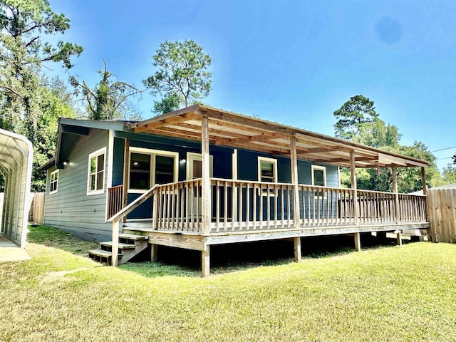 rear view of house featuring a deck and a yard