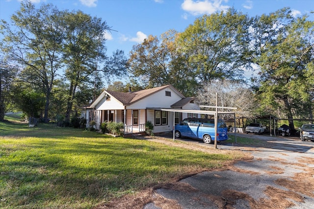 view of front of home with a carport, a porch, and a front lawn