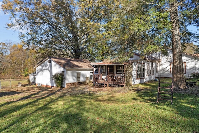 back of property with a lawn and a wooden deck