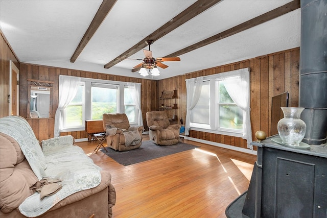 living room featuring wooden walls, light hardwood / wood-style floors, and a wealth of natural light