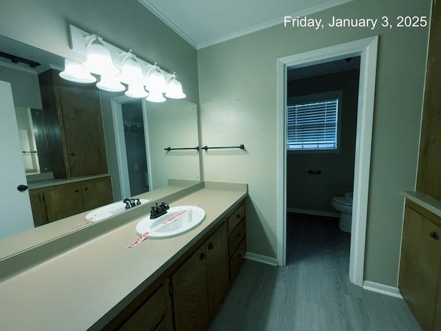 bathroom featuring crown molding, hardwood / wood-style floors, vanity, and toilet