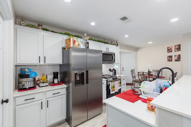 225 Jerri St, Lufkin, TX 75901 - kitchen featuring appliances with stainless steel finishes, decorative backsplash, light countertops, recessed lighting, and white cabinetry