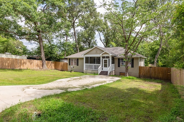 225 Jerri St, Lufkin, TX 75901 - view of front of property featuring a sunroom, roof with shingles, and a fenced backyard