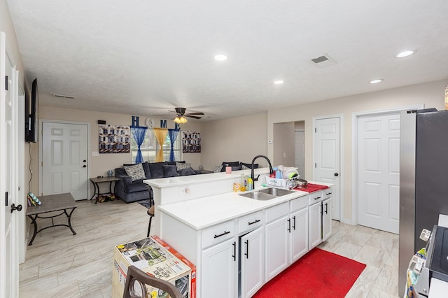 225 Jerri St, Lufkin, TX 75901 - kitchen featuring open floor plan, freestanding refrigerator, ceiling fan, white cabinets, and a kitchen island with sink