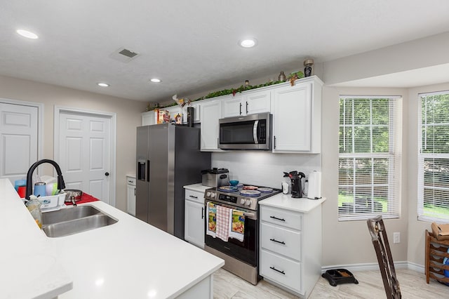 225 Jerri St, Lufkin, TX 75901 - kitchen with stainless steel appliances, light countertops, white cabinetry, backsplash, and recessed lighting