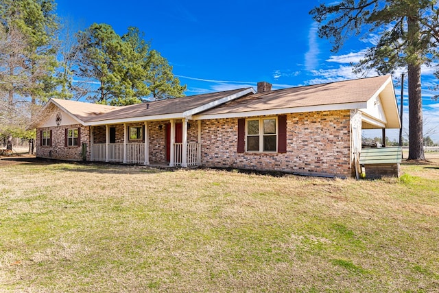 ranch-style house featuring covered porch and a front lawn