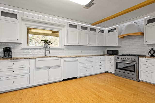 kitchen featuring white cabinetry, light hardwood / wood-style flooring, dishwasher, stainless steel stove, and custom range hood