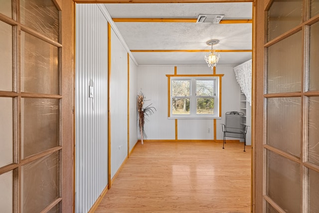 hallway featuring a textured ceiling and light hardwood / wood-style floors