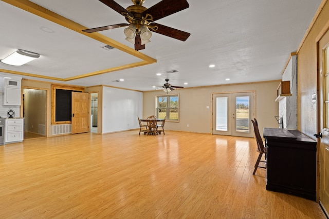 unfurnished living room featuring ornamental molding, light hardwood / wood-style flooring, ceiling fan, and french doors