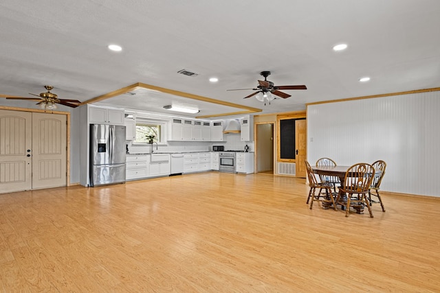 interior space with ornamental molding, sink, ceiling fan, and light hardwood / wood-style floors