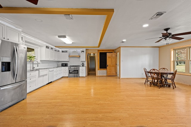 kitchen featuring stainless steel appliances, white cabinetry, premium range hood, and light hardwood / wood-style flooring