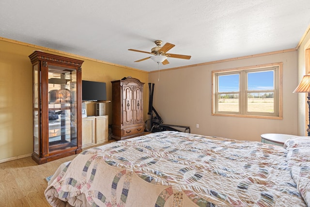 bedroom featuring ceiling fan, light hardwood / wood-style flooring, and a textured ceiling