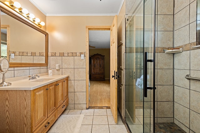 bathroom featuring crown molding, tile walls, vanity, an enclosed shower, and tile patterned floors