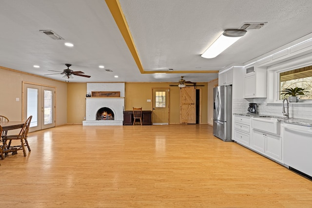 kitchen featuring light hardwood / wood-style flooring, dishwasher, white cabinetry, stainless steel fridge with ice dispenser, and french doors