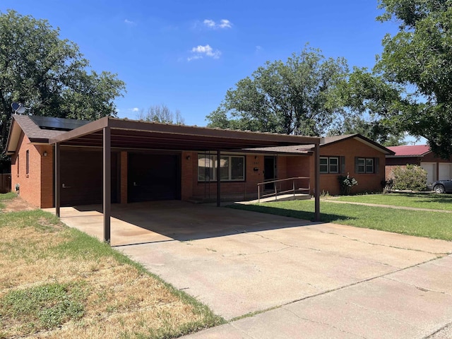 ranch-style house featuring a front lawn, solar panels, and a carport