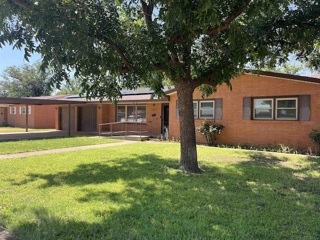 ranch-style house featuring solar panels and a front yard