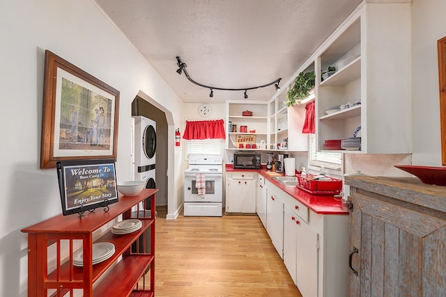 998 Winston 8 Ranch Rd, Lufkin, TX 75904 - kitchen with electric stove, stacked washing machine and dryer, open shelves, white cabinets, and light wood-style flooring